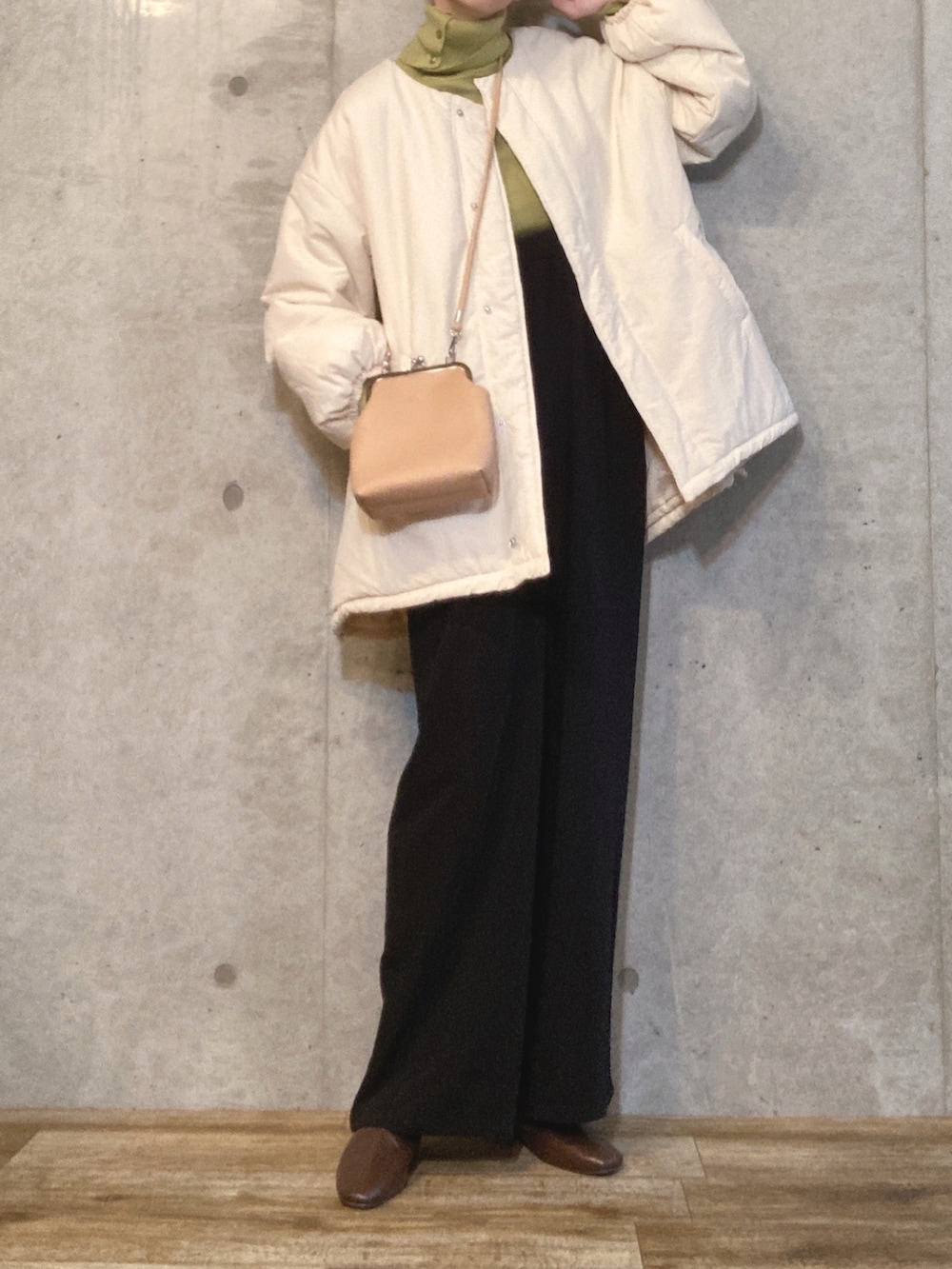 ホワイト系のブルゾン、グリーン系のニット/セーター、ブラック系のサロペット/オーバーオールを着用したレディースの秋コーディネートの2枚目の写真