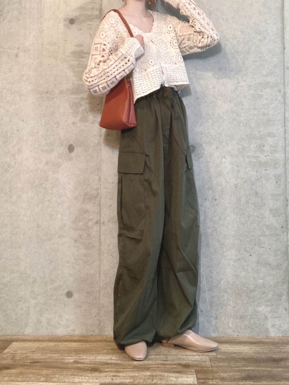 グリーン系のカーゴパンツ、ホワイト系のカーディガン/ボレロ、ブラウン系のショルダーバッグを着用したレディースの秋コーディネートの2枚目の写真