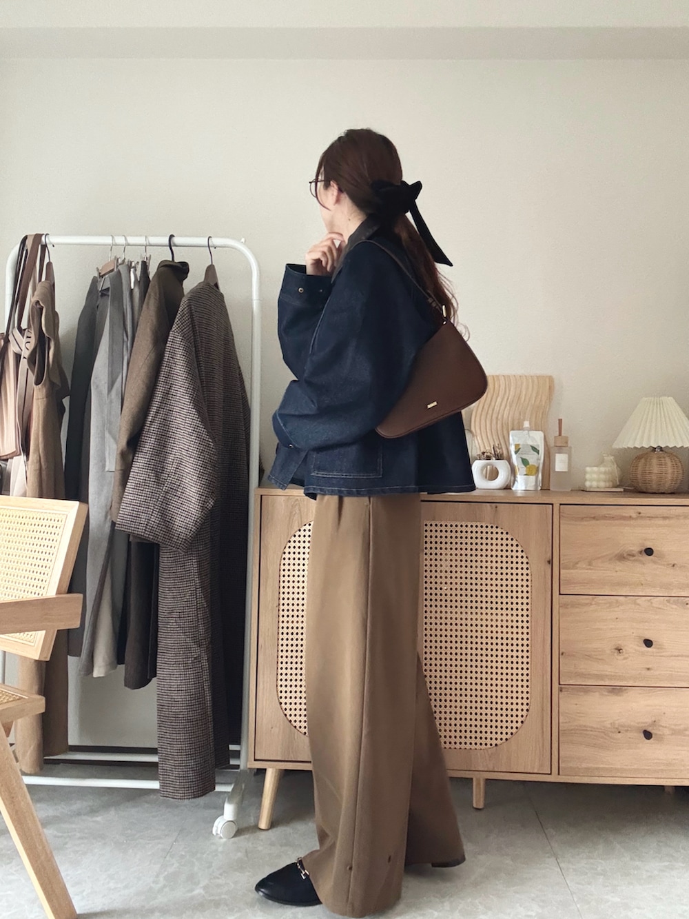 ブラウン系のハンドバッグ、ブルー系のカバーオール、イエロー系のその他パンツを着用したレディースの春コーディネートの2枚目の写真