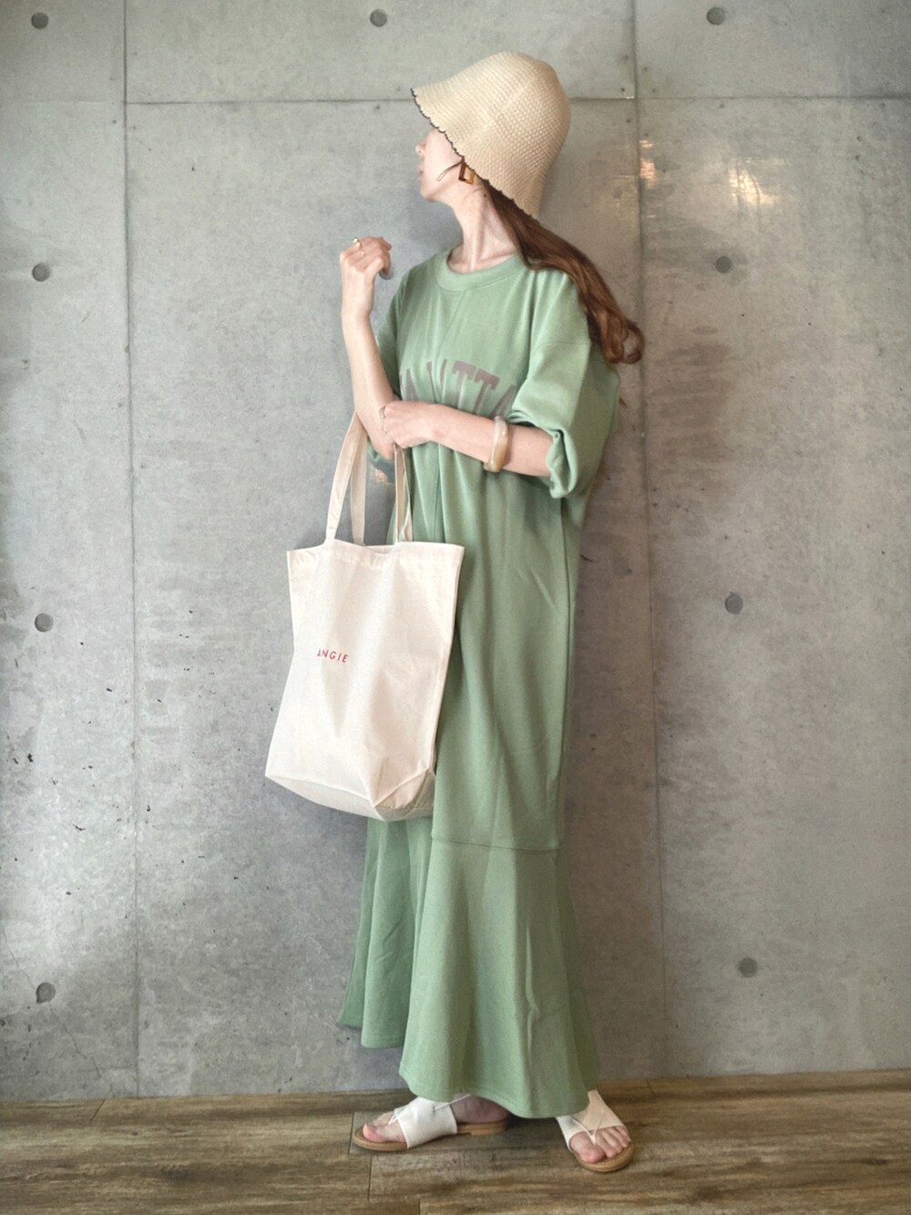 グリーン系のワンピース、ホワイト系のトートバッグ、ホワイト系のサンダルを着用したレディースの春コーディネートの2枚目の写真