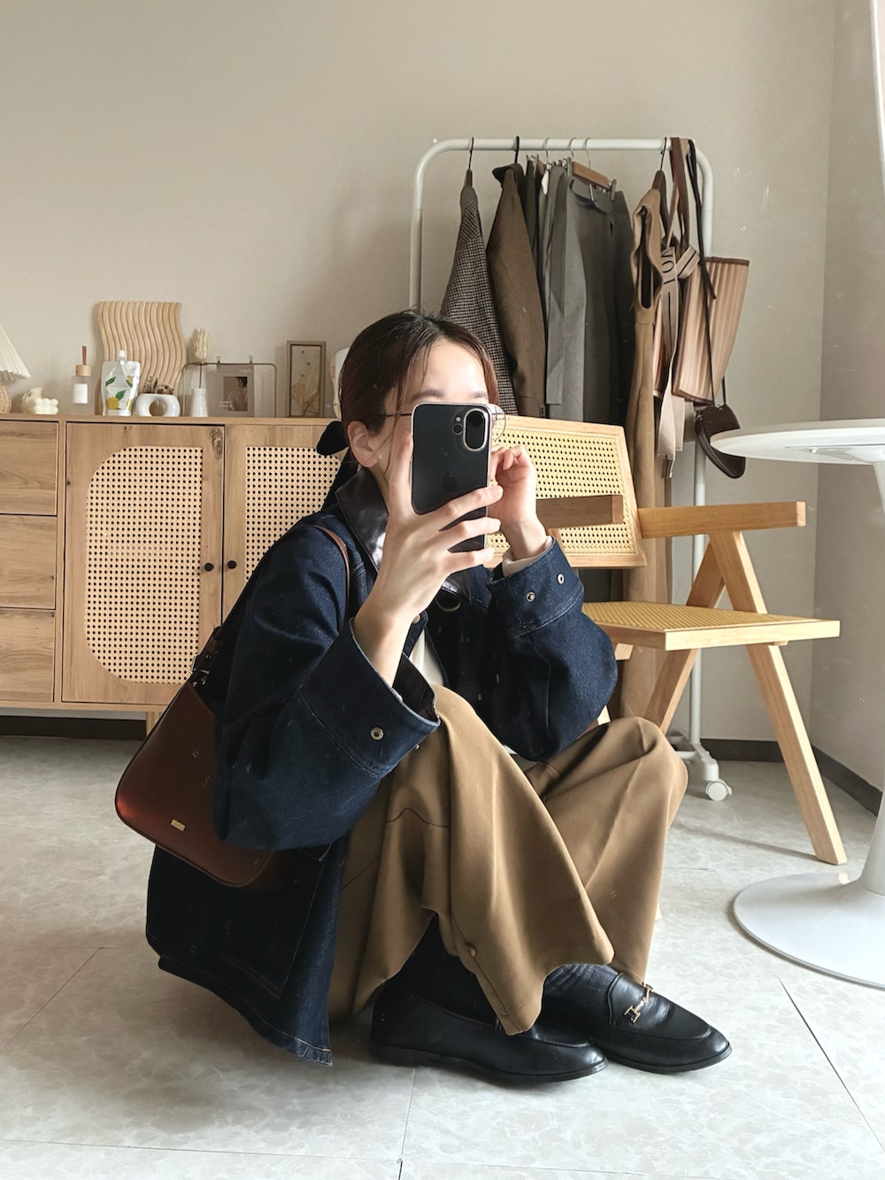 ブラウン系のハンドバッグ、ブルー系のカバーオール、イエロー系のその他パンツを着用したレディースの春コーディネートの5枚目の写真