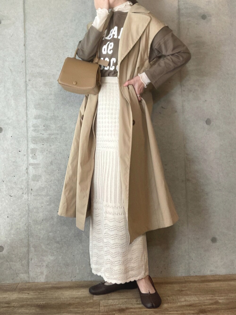 ベージュ系のTシャツ/カットソー、ベージュ系のトレンチコート、ホワイト系のシャツ/ブラウスを着用したレディースの春コーディネートの2枚目の写真