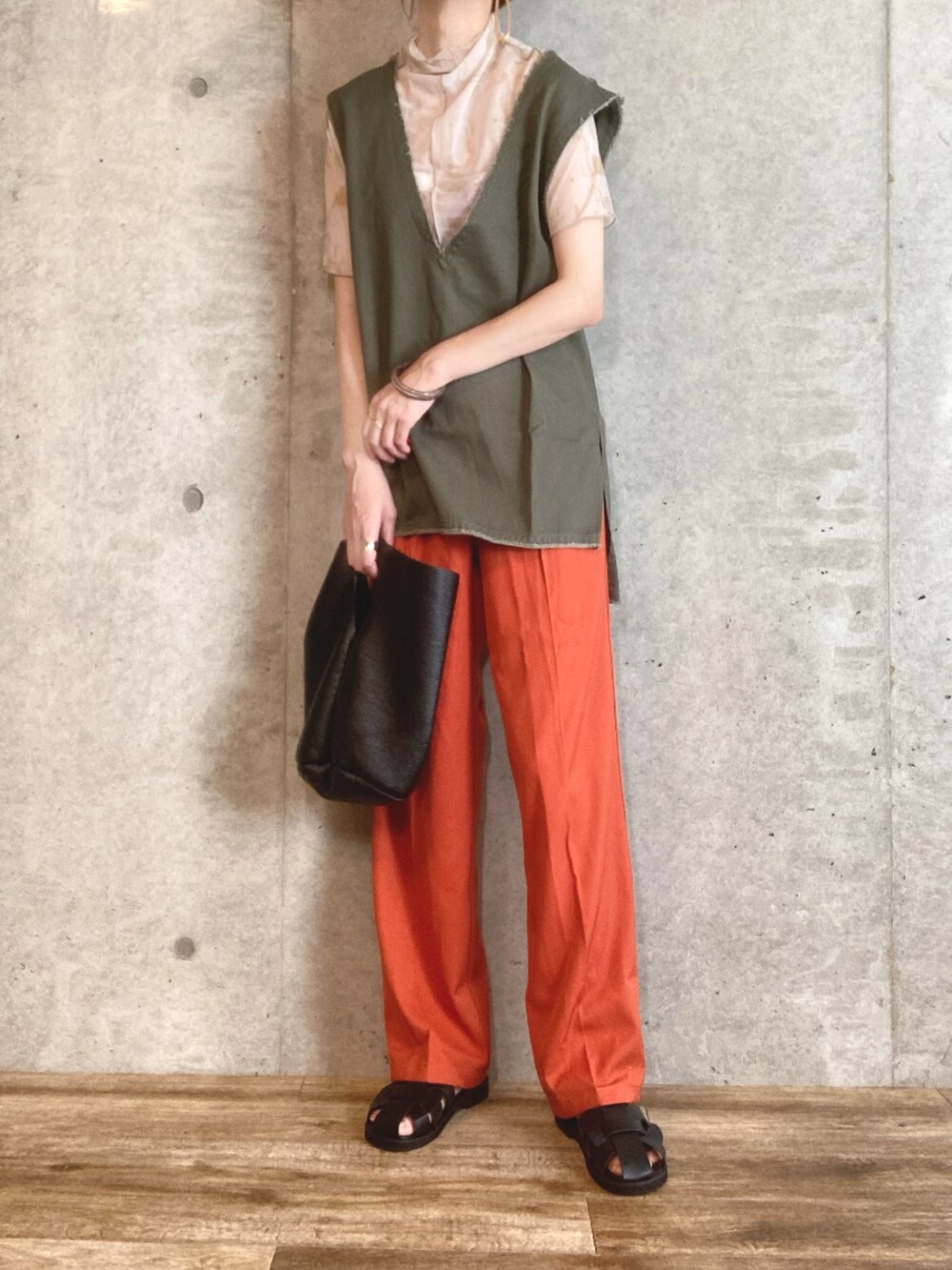 グリーン系のベスト、ベージュ系のTシャツ/カットソー、オレンジ系のスラックスを着用したレディースの夏コーディネートの2枚目の写真