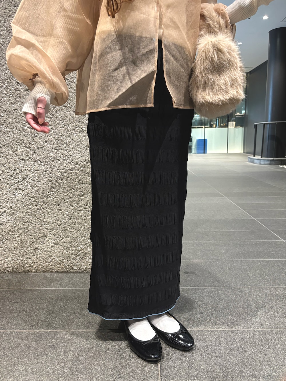 ホワイト系のニット/セーター、ベージュ系のシャツ/ブラウス、ブラック系のスカートを着用したレディースの秋コーディネートの3枚目の写真