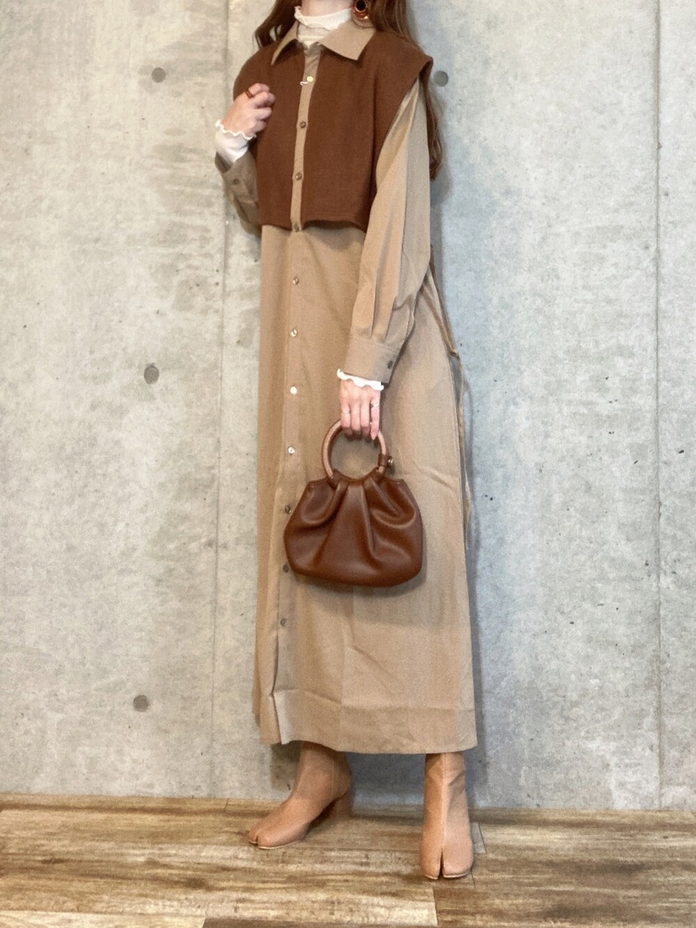 ベージュ系のワンピース、ブラウン系のトートバッグ、ベージュ系のブーツを着用したレディースの秋コーディネートの2枚目の写真