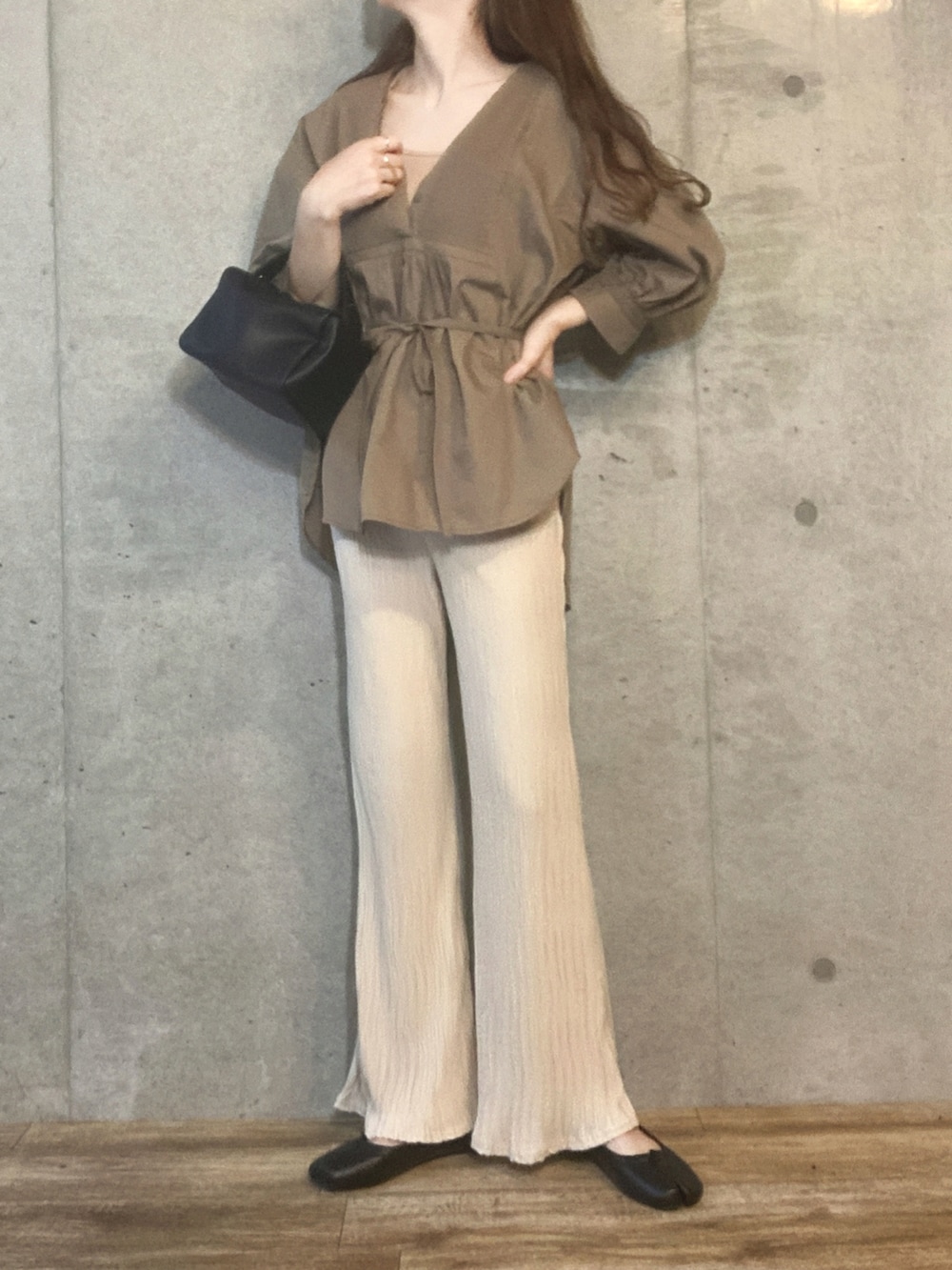 ベージュ系のキャミソール、ブラック系のショルダーバッグ、ホワイト系のその他パンツを着用したレディースの春コーディネートの3枚目の写真