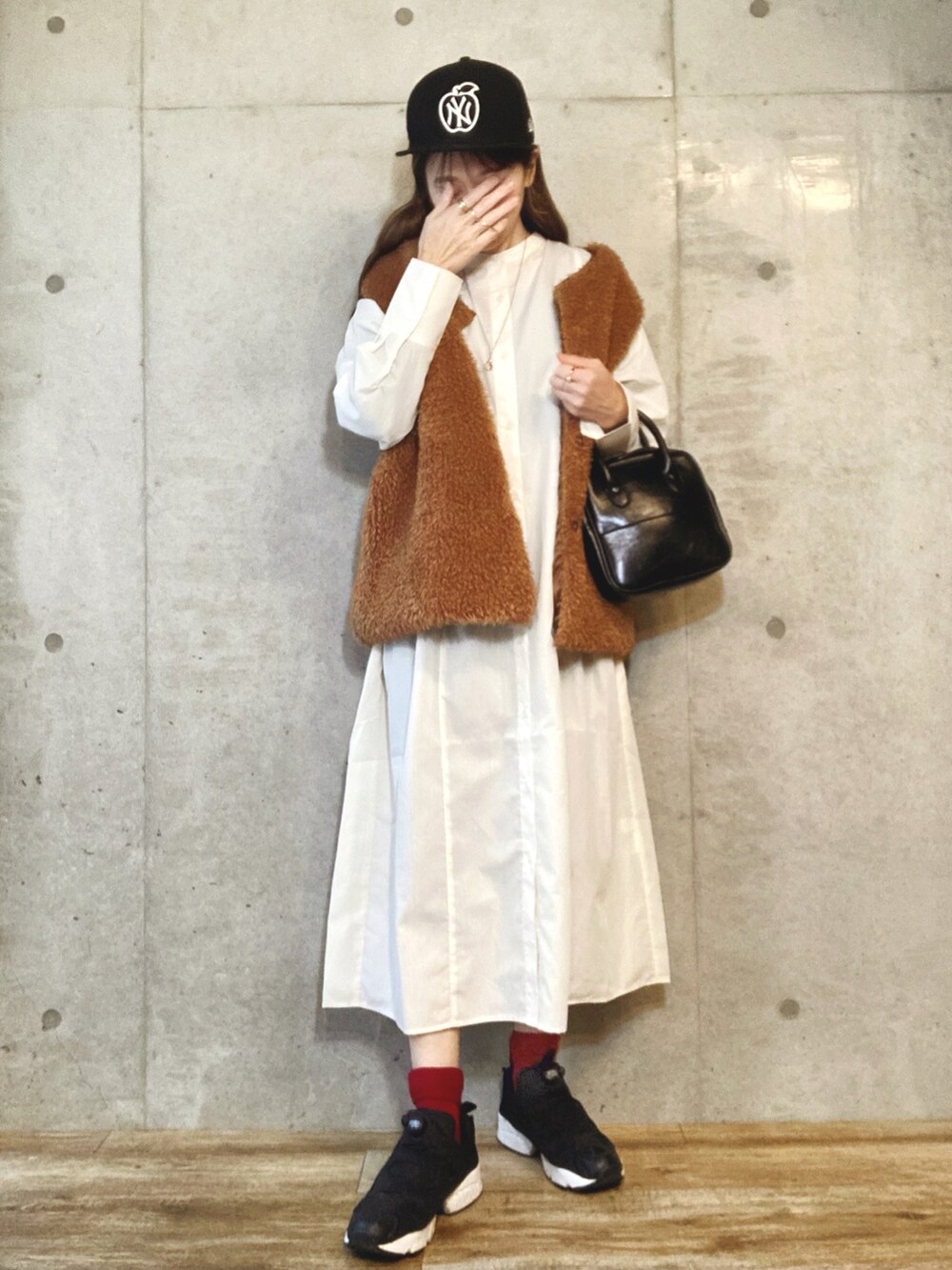 ホワイト系のワンピース、ブラック系のショルダーバッグ、シルバー系のネックレスを着用したレディースの春コーディネートの2枚目の写真