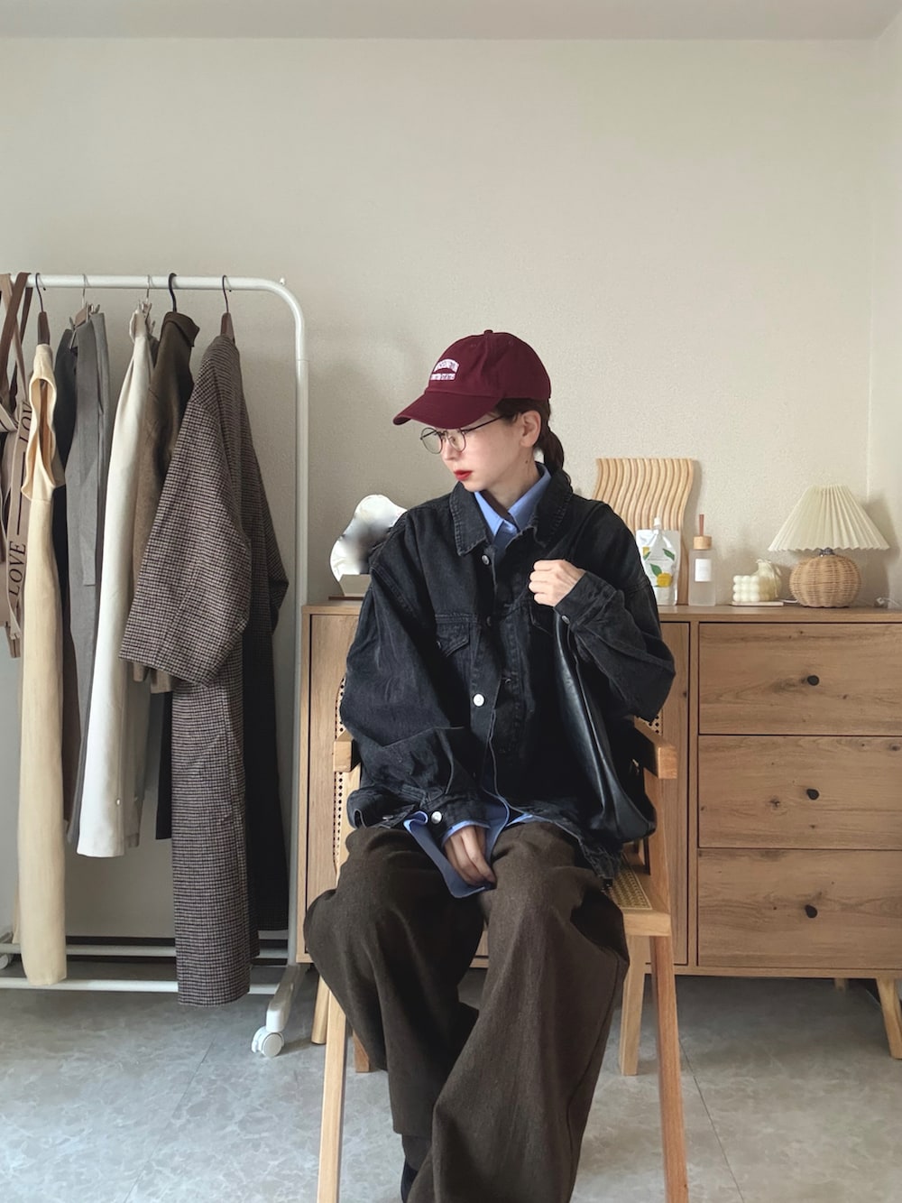 ブラック系のデニムジャケット、ブラック系のブーツ、ブラック系のトートバッグを着用したレディースの冬コーディネートの3枚目の写真