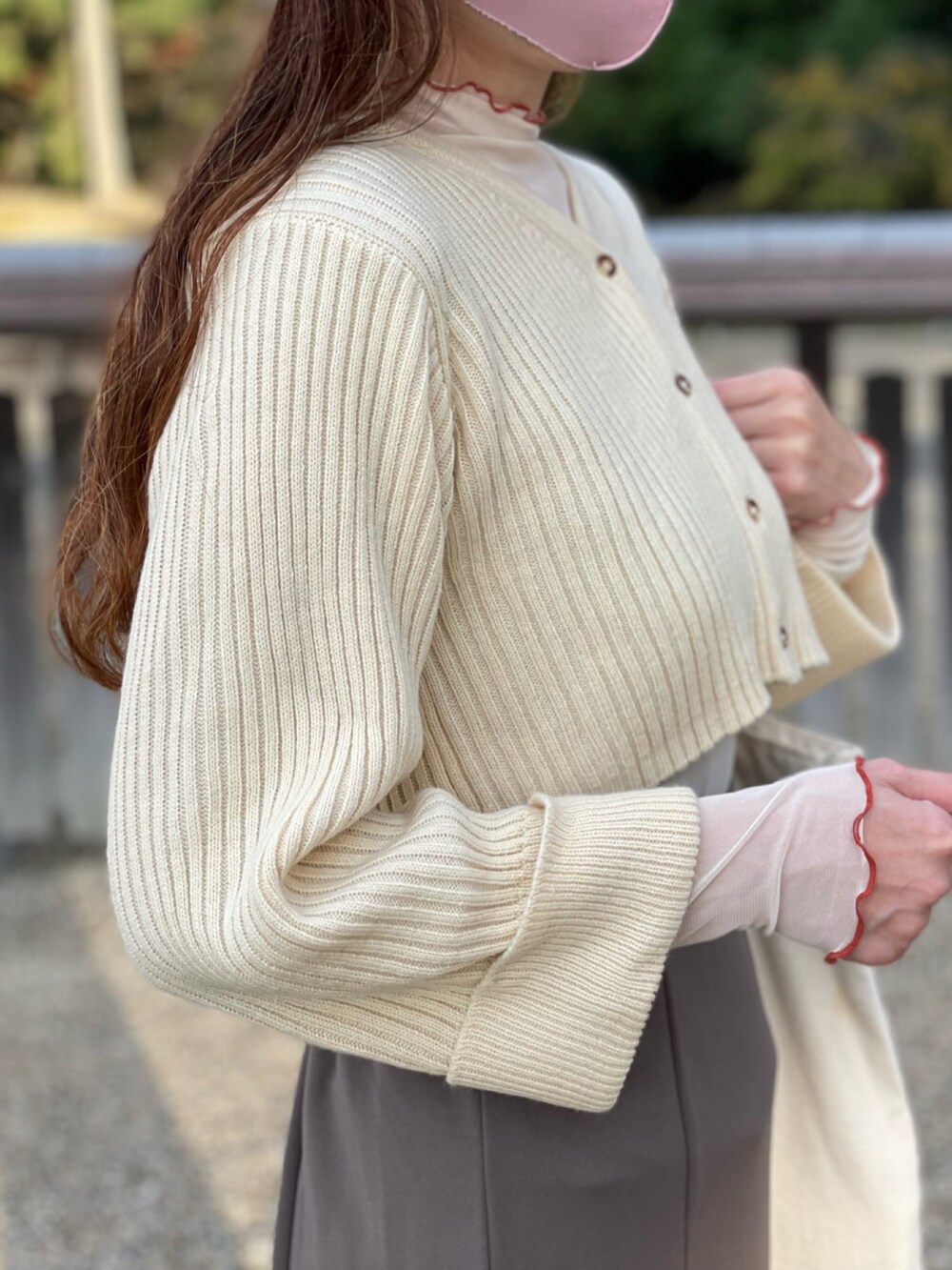 ホワイト系のカーディガン/ボレロ、ホワイト系のトートバッグ、ホワイト系のハットを着用したレディースの秋コーディネートの2枚目の写真