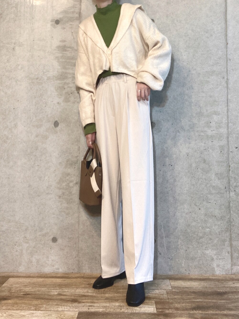 ホワイト系のカーディガン/ボレロ、グリーン系のTシャツ/カットソー、ブラウン系のハンドバッグを着用したレディースの秋コーディネートの2枚目の写真