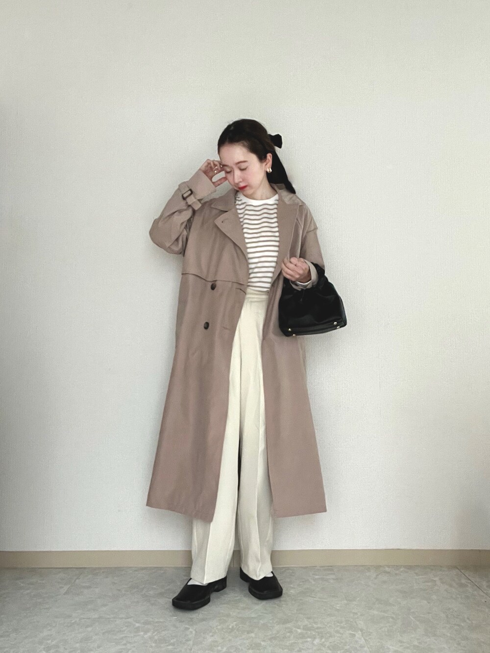 ベージュ系のトレンチコート、ベージュ系のTシャツ/カットソー、ホワイト系のその他パンツを着用したレディースの春コーディネートの2枚目の写真