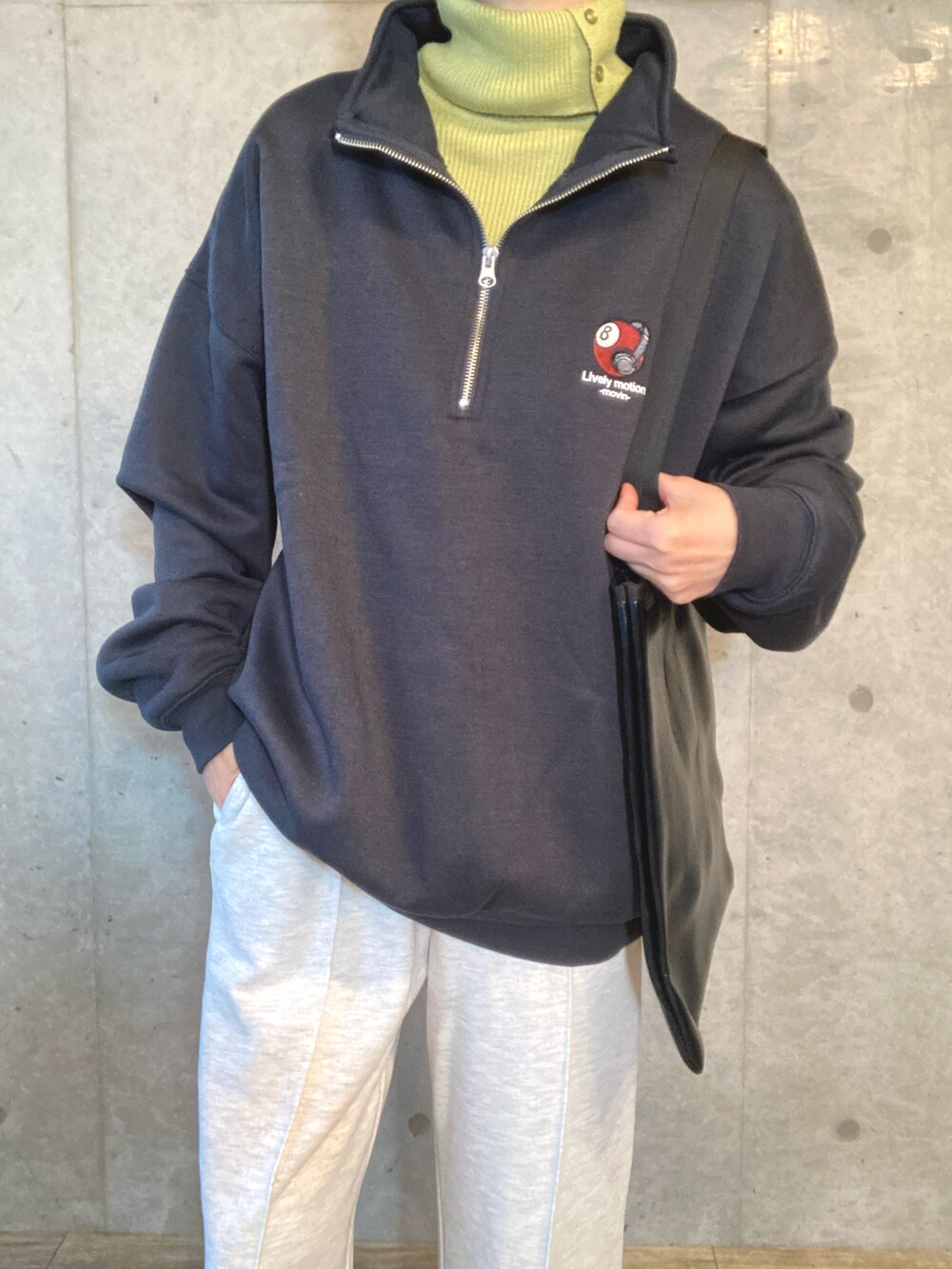 グレー系のスウェット、グリーン系のニット/セーター、ベージュ系のスウェットパンツを着用したレディースの秋コーディネートの3枚目の写真