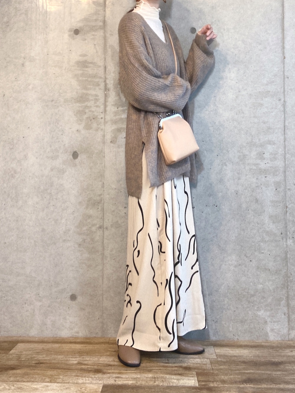 ベージュ系のニット/セーター、ベージュ系のTシャツ/カットソー、ホワイト系のワンピースを着用したレディースの秋コーディネートの2枚目の写真