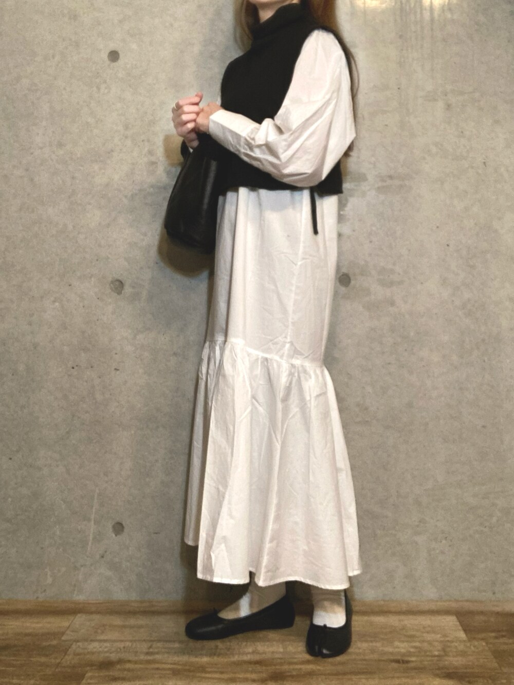 ブラック系のトートバッグ、ブラック系のバレエシューズ、ホワイト系のワンピースを着用したレディースの冬コーディネートの4枚目の写真