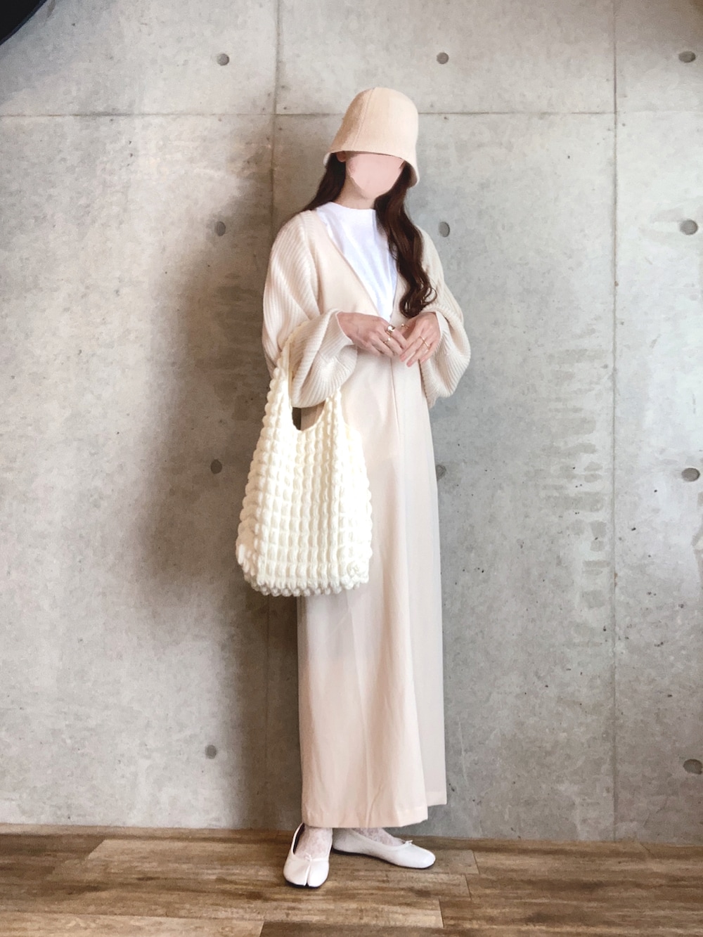 ホワイト系のカーディガン/ボレロ、ホワイト系のジャンパースカート、ホワイト系のバレエシューズを着用したレディースの春コーディネートの3枚目の写真