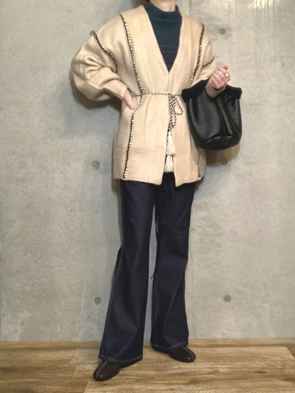 ホワイト系のカーディガン/ボレロ、グリーン系のトップス、ブラック系のトートバッグを着用したレディースの冬コーディネートの2枚目の写真