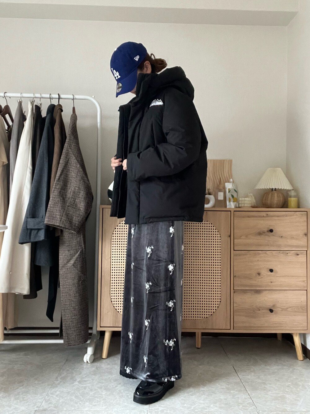 ブラック系のダウンジャケット/コート、グレー系のスカート、ブルー系のシャツ/ブラウスを着用したレディースの冬コーディネートの2枚目の写真