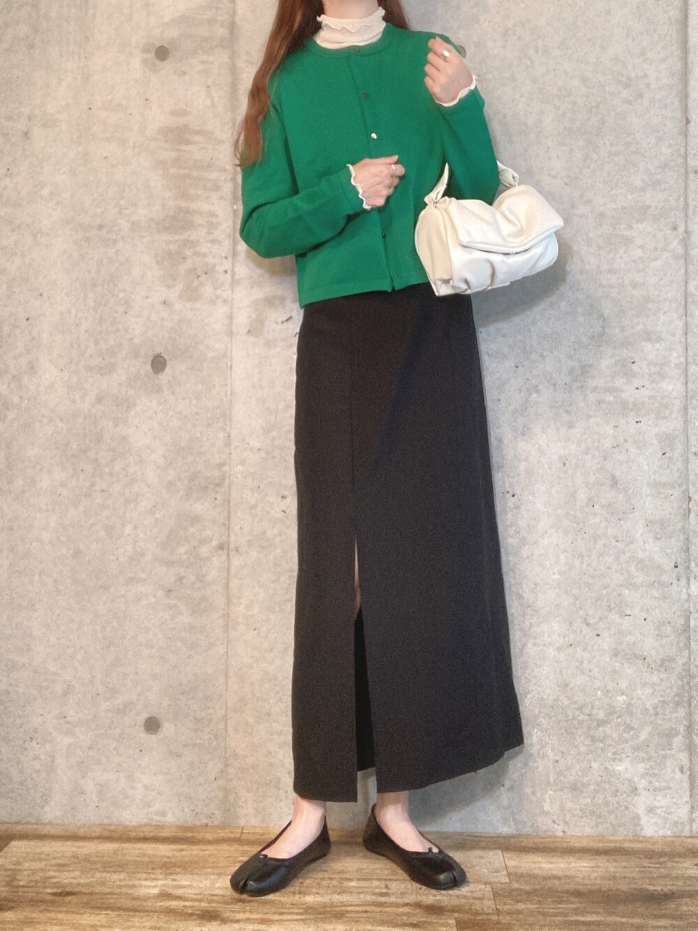 グリーン系のカーディガン/ボレロ、ブラック系のワンピース、ホワイト系のショルダーバッグを着用したレディースの夏コーディネートの2枚目の写真
