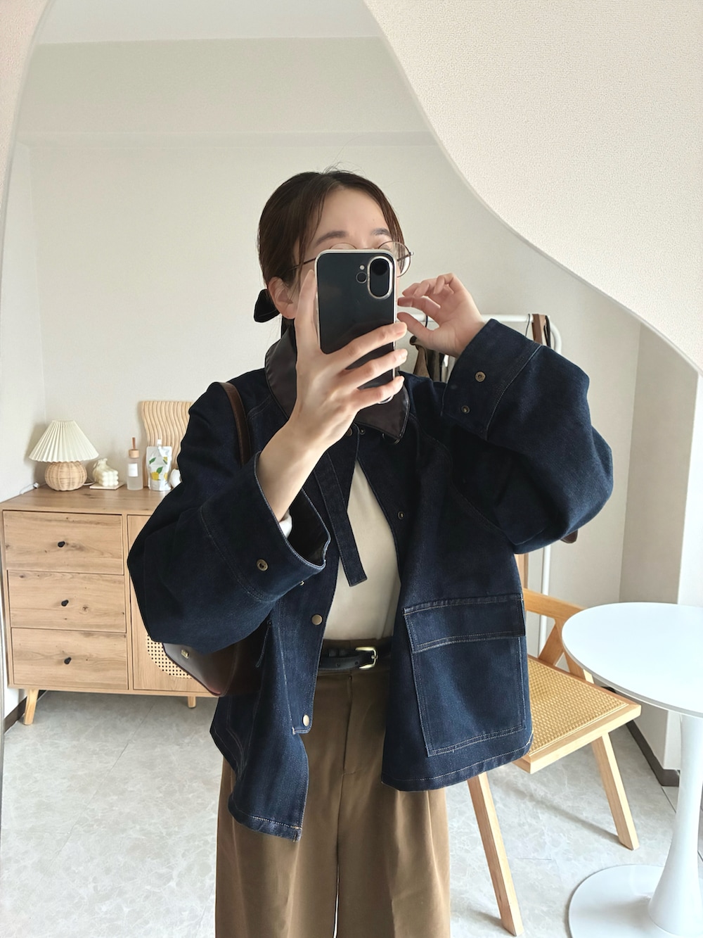 ブラウン系のハンドバッグ、ブルー系のカバーオール、イエロー系のその他パンツを着用したレディースの春コーディネートの3枚目の写真