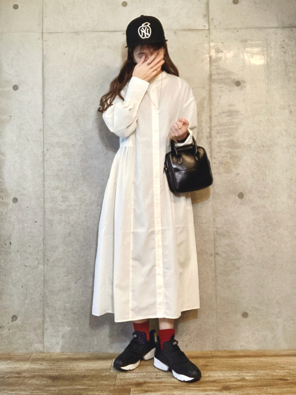 ホワイト系のワンピース、ブラック系のショルダーバッグ、シルバー系のネックレスを着用したレディースの春コーディネートの3枚目の写真