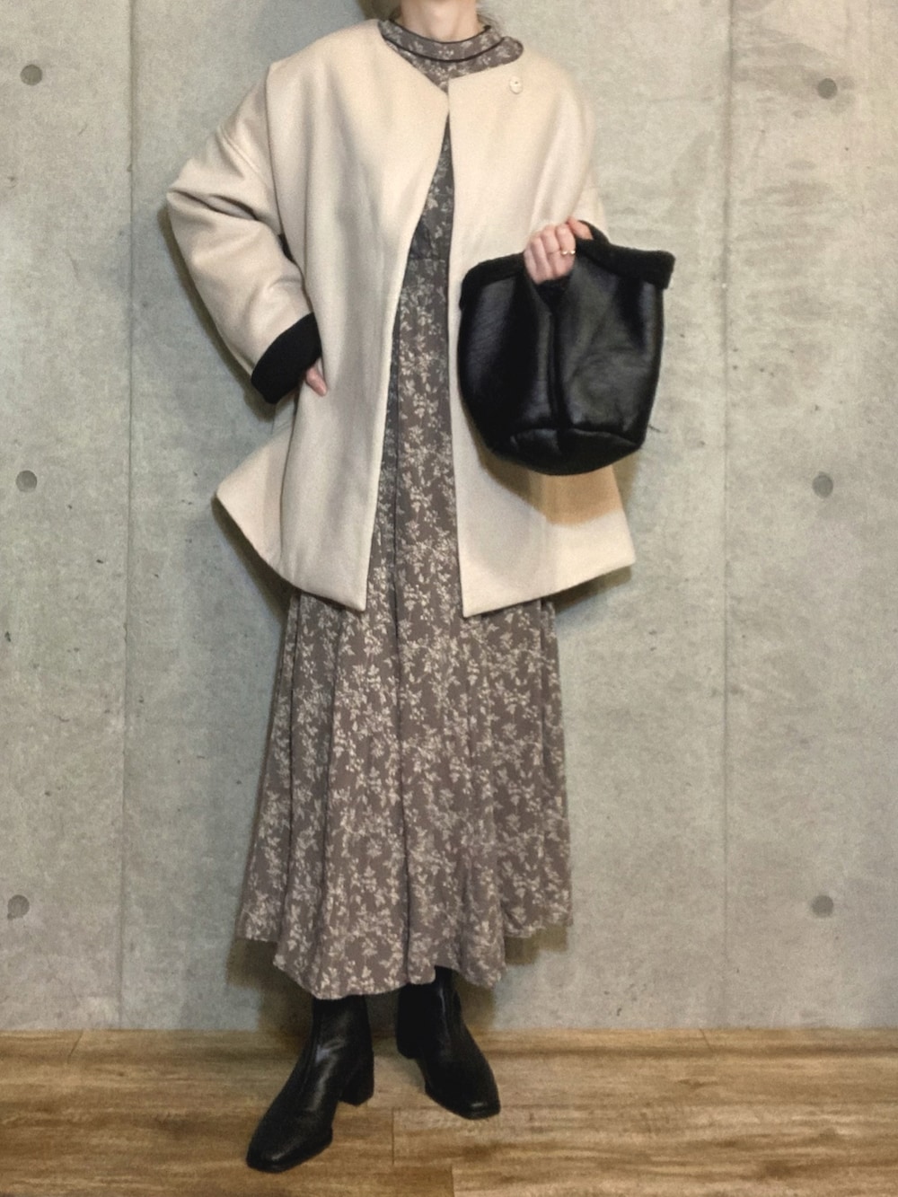 グレー系のワンピース、ブラック系のブーツ、ブラック系のトートバッグを着用したレディースの冬コーディネートの2枚目の写真
