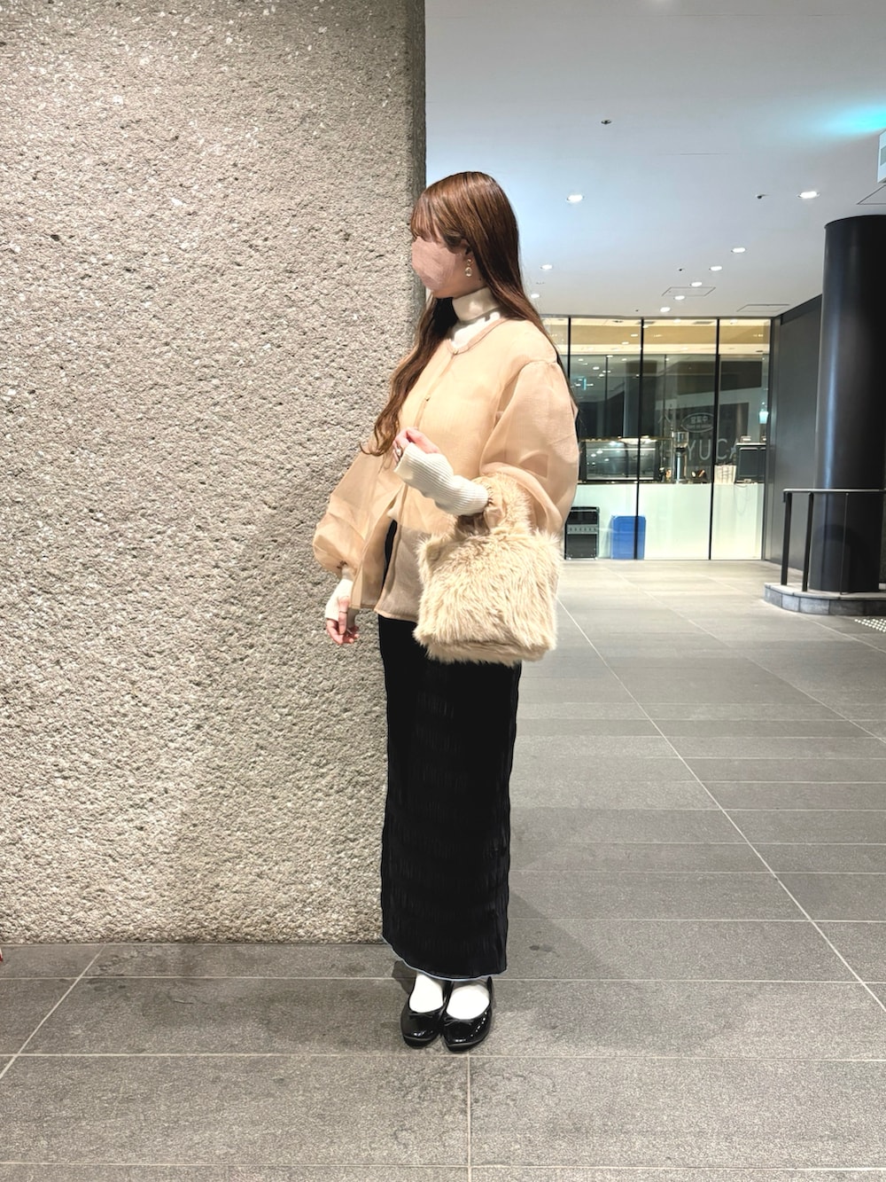 ホワイト系のニット/セーター、ベージュ系のシャツ/ブラウス、ブラック系のスカートを着用したレディースの秋コーディネートの2枚目の写真