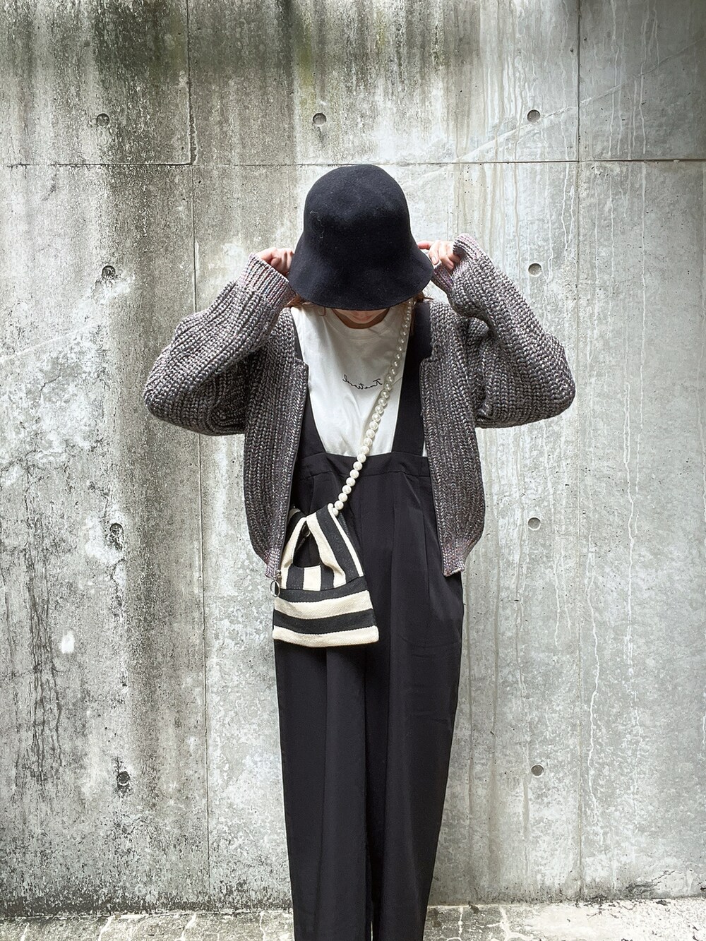 グレー系のニット/セーター、ホワイト系のTシャツ/カットソー、ホワイト系のショルダーバッグを着用したレディースの秋コーディネートの4枚目の写真