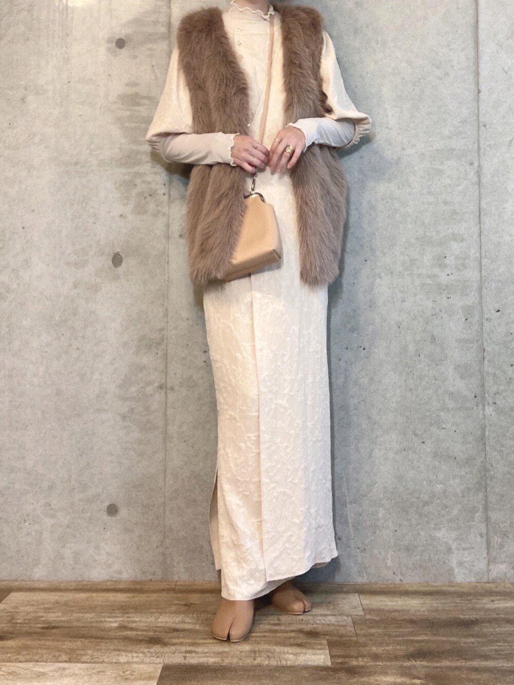 ブラウン系のベスト、ベージュ系のショルダーバッグ、ベージュ系のブーツを着用したレディースの秋コーディネートの3枚目の写真