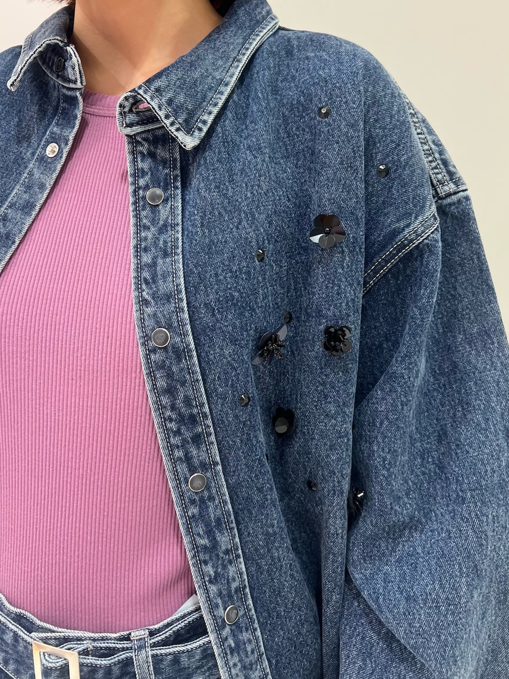 ブルー系のシャツ/ブラウス、パープル系のタンクトップ、ブルー系のデニムパンツを着用したレディースの秋コーディネートの5枚目の写真