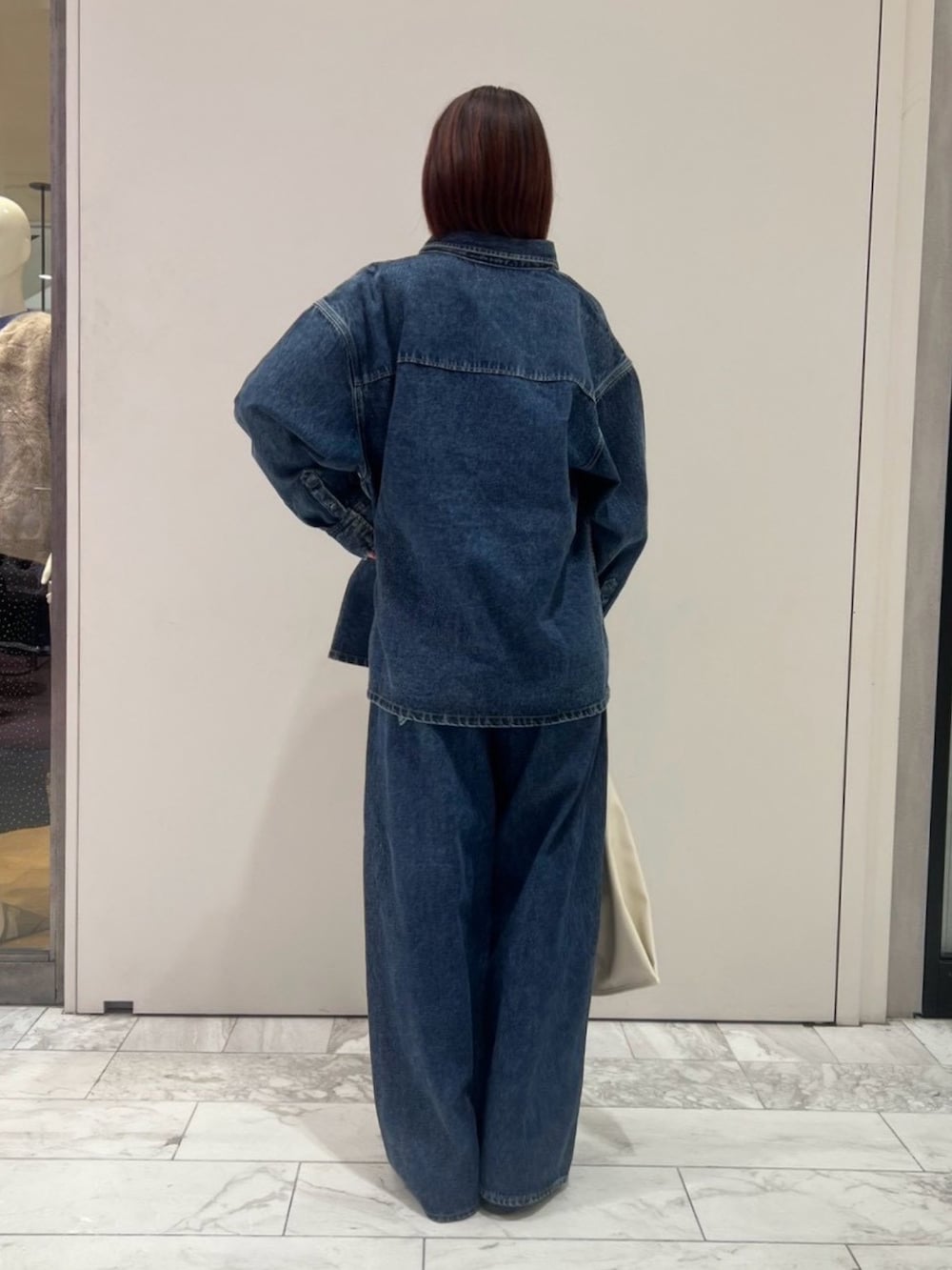 ブルー系のシャツ/ブラウス、パープル系のタンクトップ、ブルー系のデニムパンツを着用したレディースの秋コーディネートの3枚目の写真