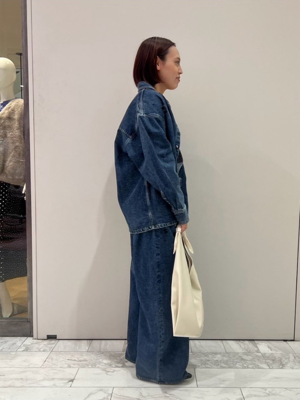 ブルー系のシャツ/ブラウス、パープル系のタンクトップ、ブルー系のデニムパンツを着用したレディースの秋コーディネートの4枚目の写真
