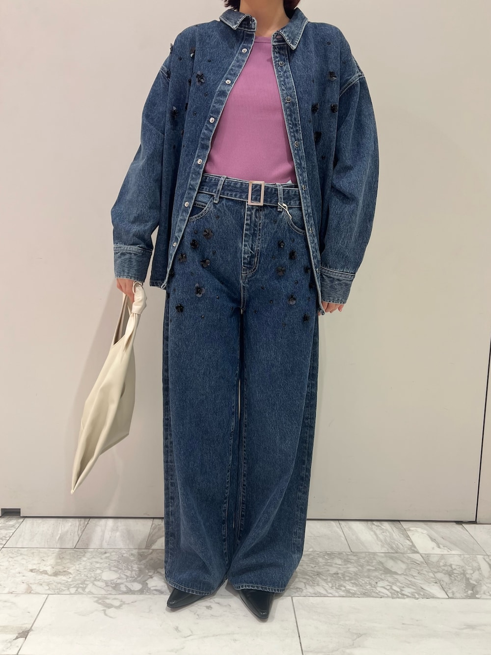 ブルー系のシャツ/ブラウス、パープル系のタンクトップ、ブルー系のデニムパンツを着用したレディースの秋コーディネートの6枚目の写真