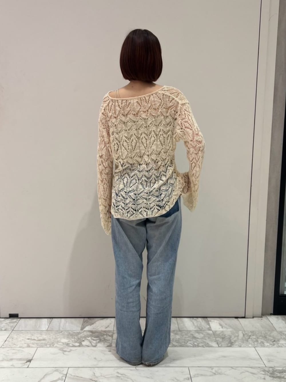 ホワイト系のニット/セーター、ブルー系のデニムパンツを着用したレディースの秋コーディネートの3枚目の写真