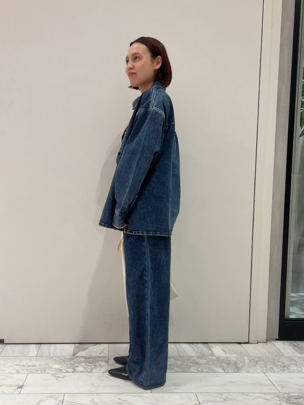 ブルー系のシャツ/ブラウス、パープル系のタンクトップ、ブルー系のデニムパンツを着用したレディースの秋コーディネートの2枚目の写真