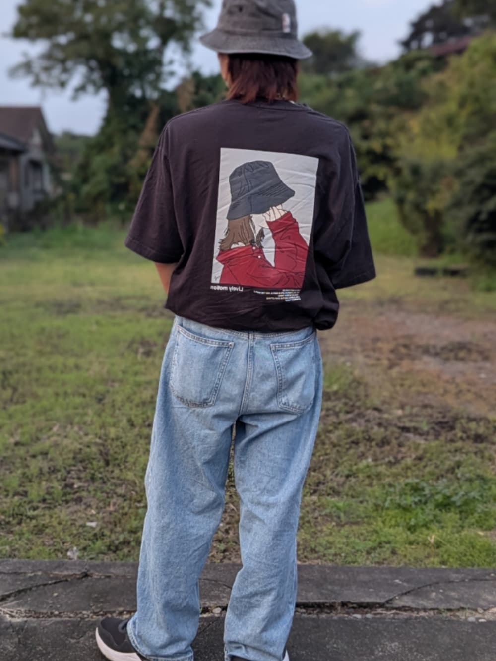 ブラック系のスニーカー、ブルー系のデニムパンツ、ブラック系のTシャツ/カットソーを着用したメンズの秋コーディネートの2枚目の写真