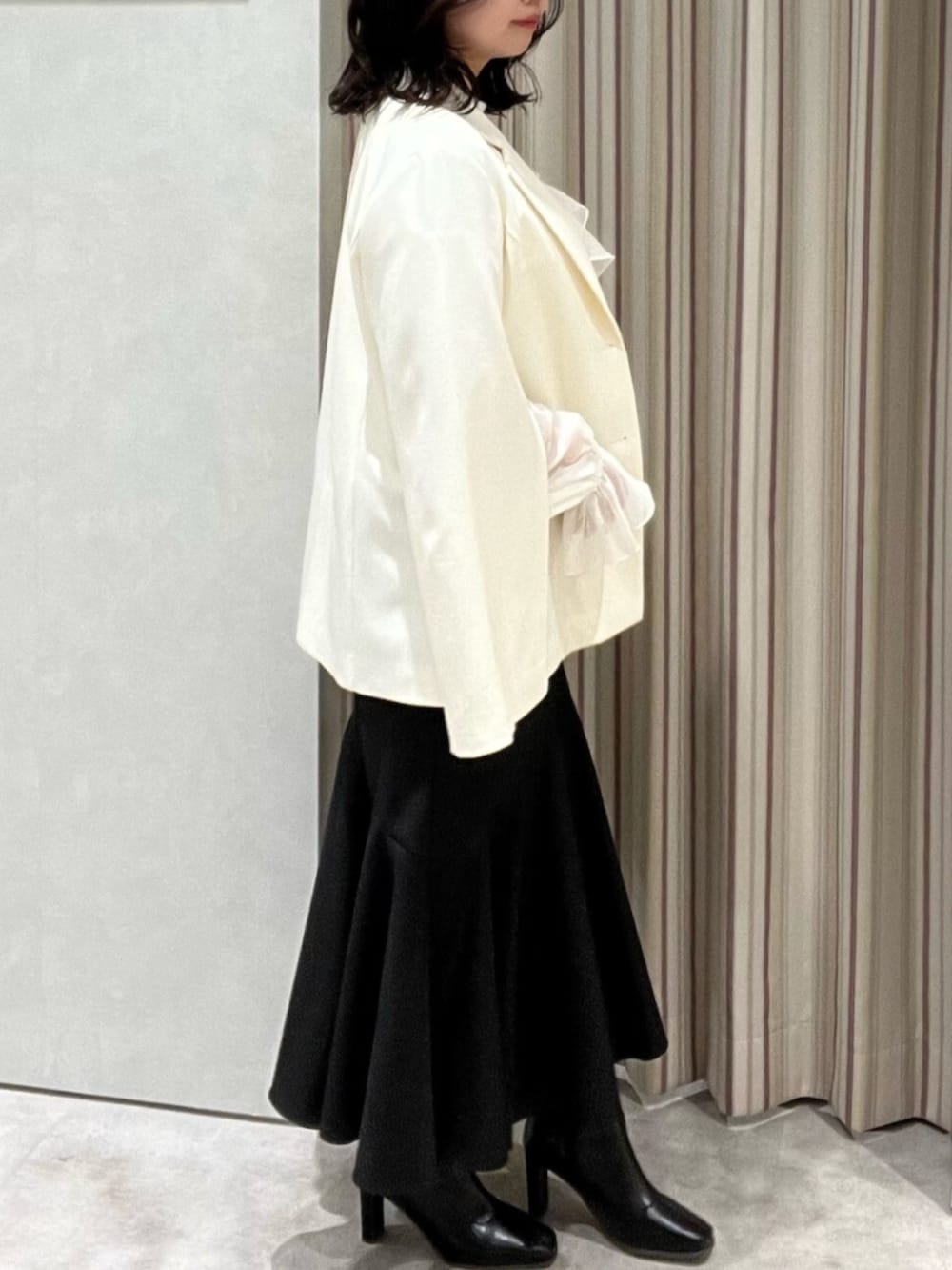 ブラック系のブーツ、ホワイト系のシャツ/ブラウス、ブラック系のスカートを着用したレディースの春コーディネートの2枚目の写真