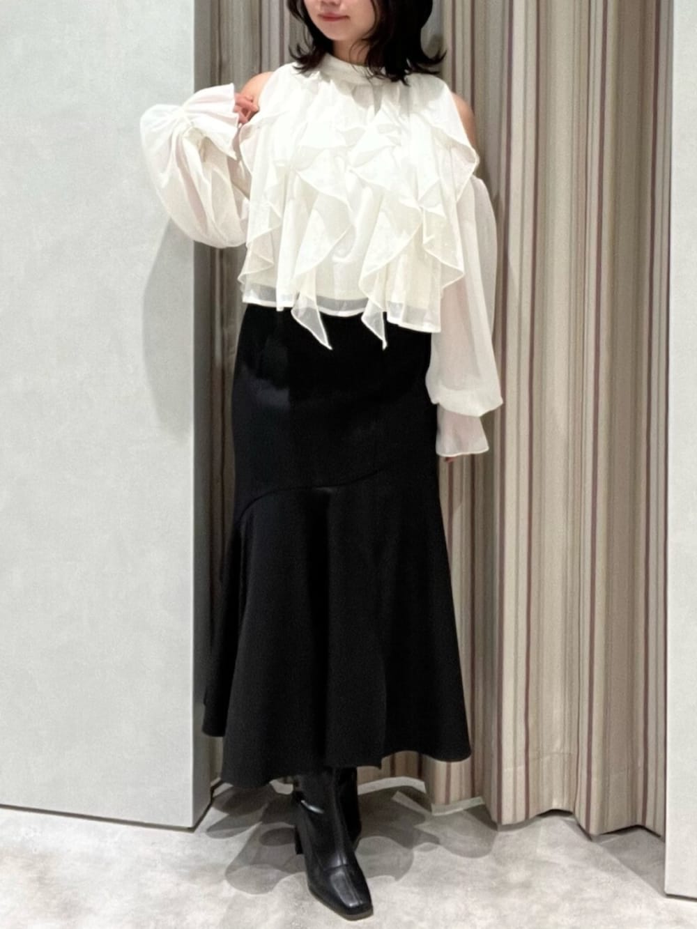 ブラック系のブーツ、ホワイト系のシャツ/ブラウス、ブラック系のスカートを着用したレディースの春コーディネートの2枚目の写真