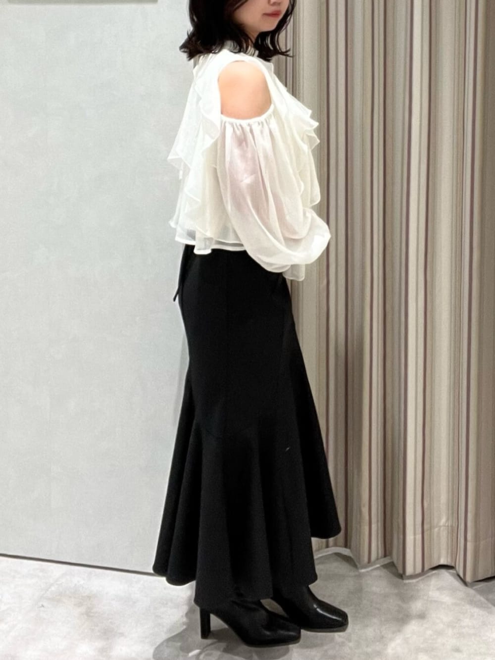 ブラック系のブーツ、ホワイト系のシャツ/ブラウス、ブラック系のスカートを着用したレディースの春コーディネートの3枚目の写真