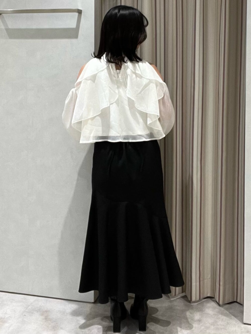 ブラック系のブーツ、ホワイト系のシャツ/ブラウス、ブラック系のスカートを着用したレディースの春コーディネートの4枚目の写真