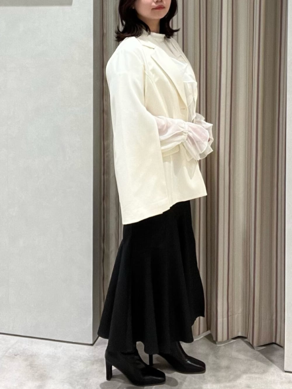 ブラック系のブーツ、ホワイト系のシャツ/ブラウス、ブラック系のスカートを着用したレディースの春コーディネートの3枚目の写真