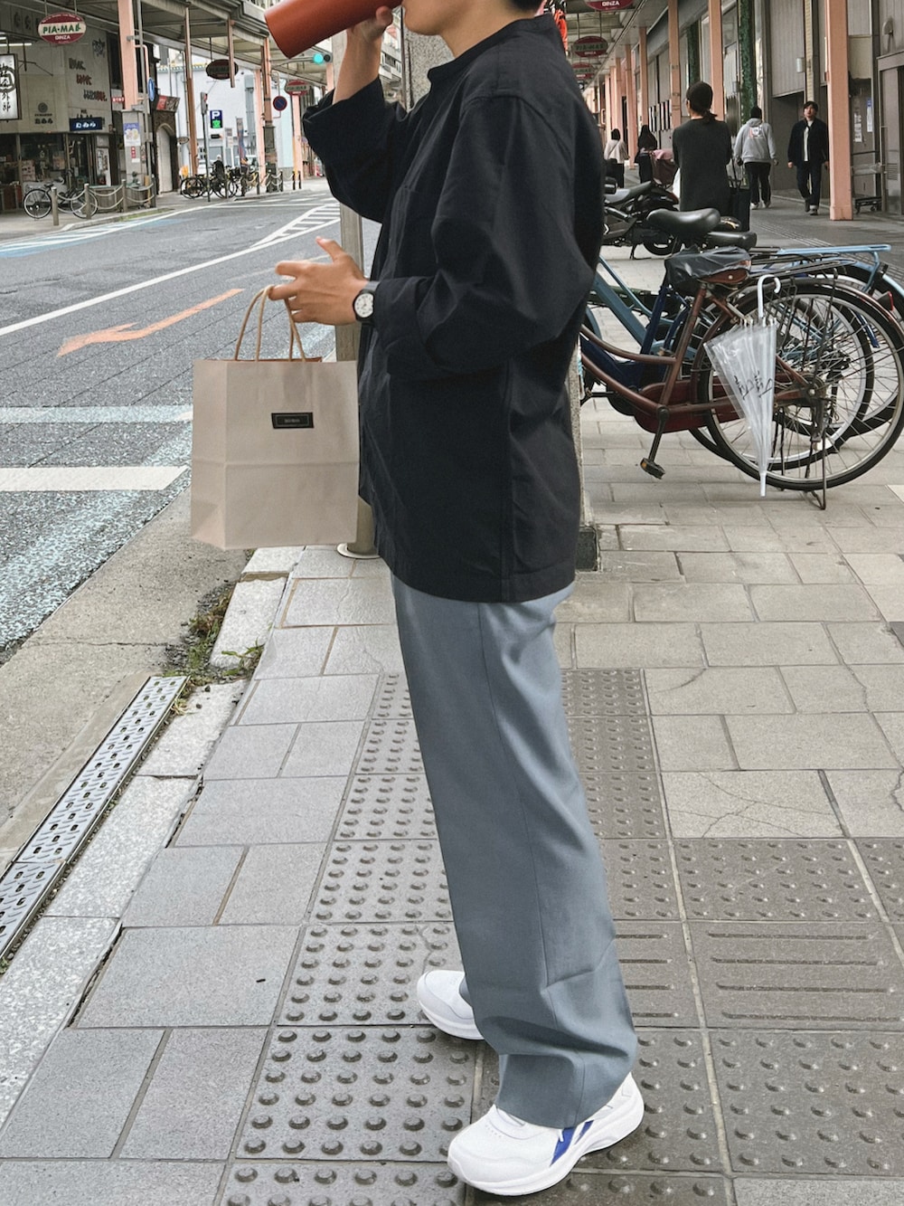 ブラック系のシャツ/ブラウス、ブルー系のスラックス、ホワイト系のスニーカーを着用したレディースの秋コーディネートの2枚目の写真