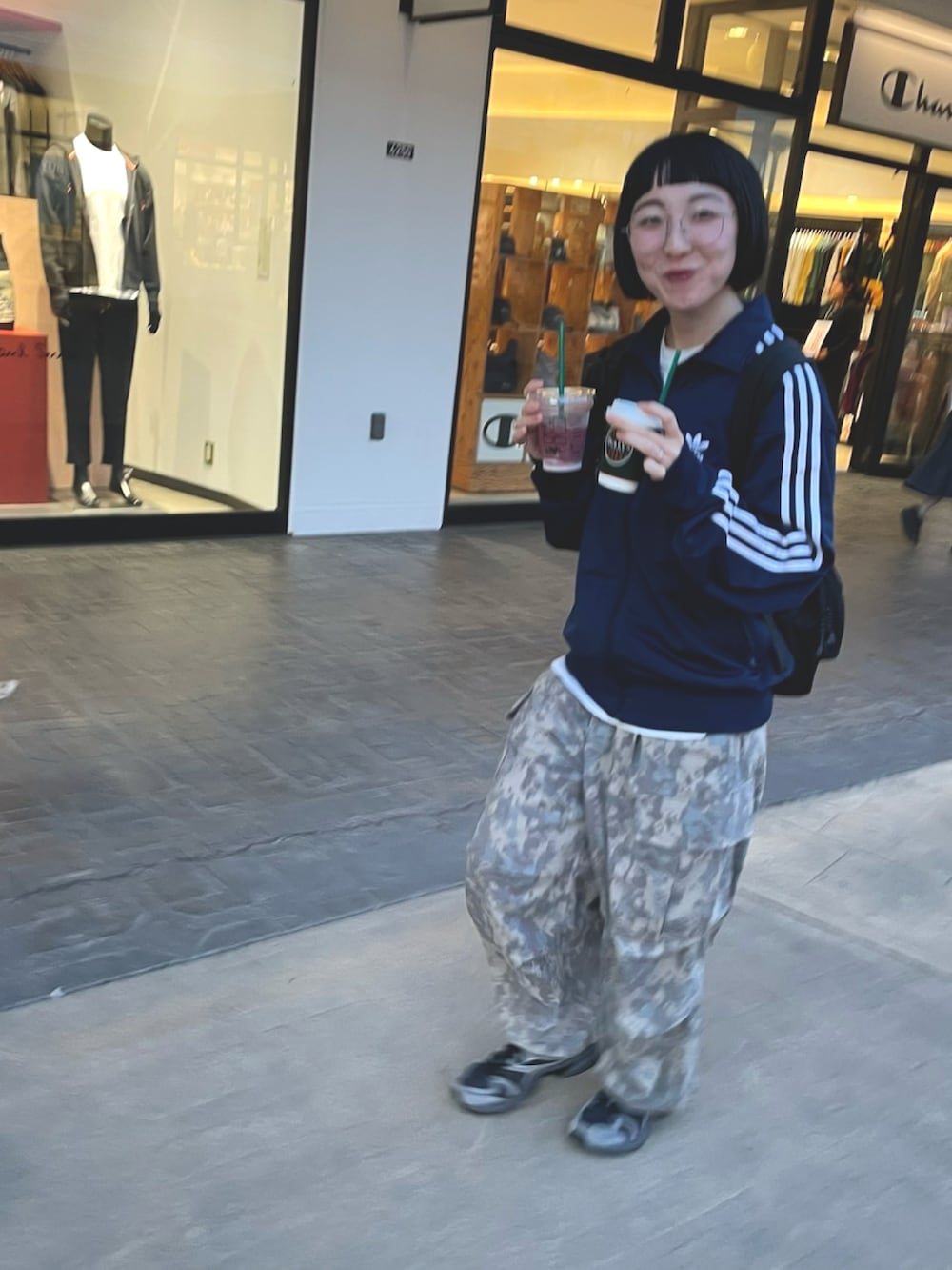 ブルー系のジャージ、グレー系のパンツ、グレー系のスニーカーを着用したレディースの秋コーディネートの2枚目の写真