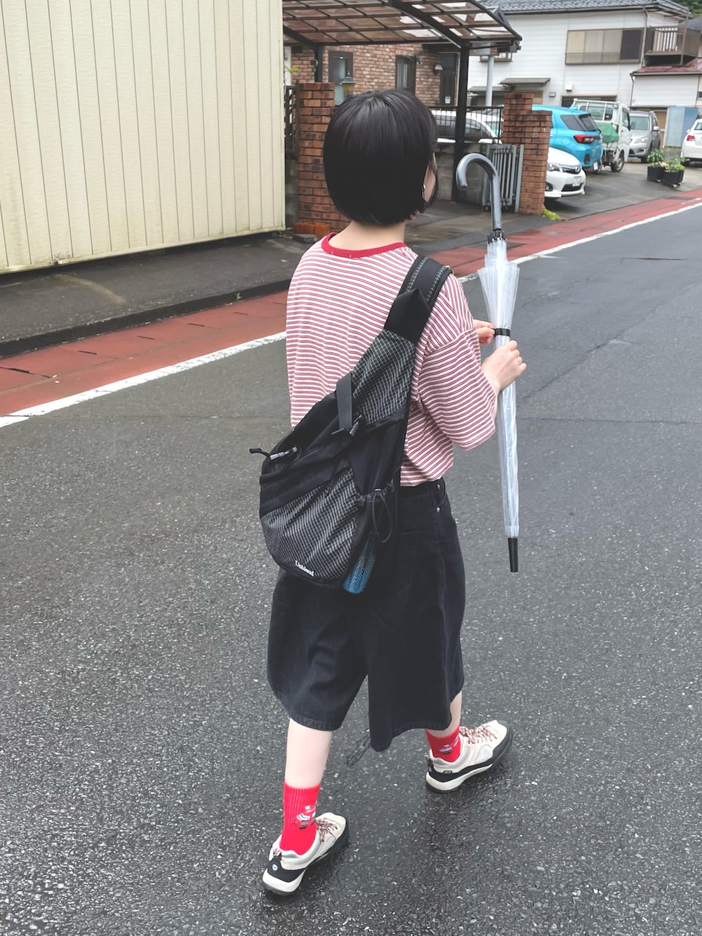 ブラック系のデニムパンツ、ベージュ系のスニーカー、ブラック系のボディバッグ/ウエストポーチを着用したレディースの夏コーディネートの3枚目の写真
