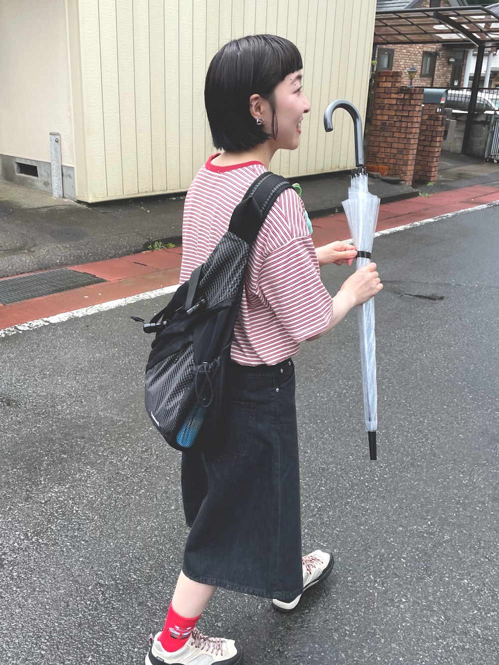 ブラック系のデニムパンツ、ベージュ系のスニーカー、ブラック系のボディバッグ/ウエストポーチを着用したレディースの夏コーディネートの2枚目の写真