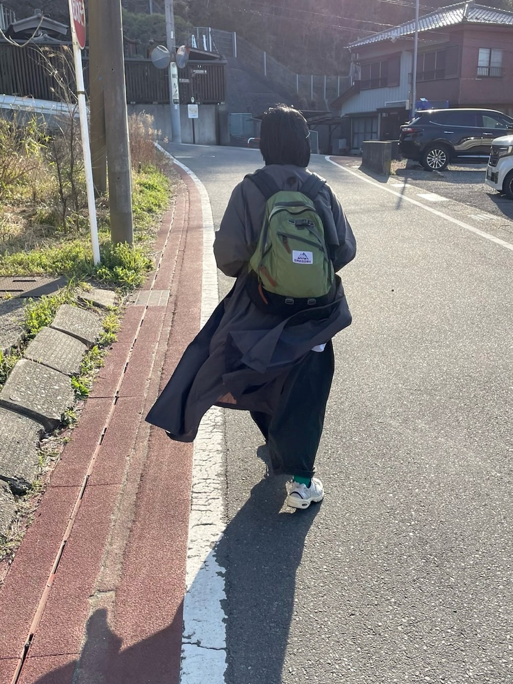 グレー系のステンカラーコート、シルバー系のスニーカーを着用したレディースの春コーディネートの2枚目の写真