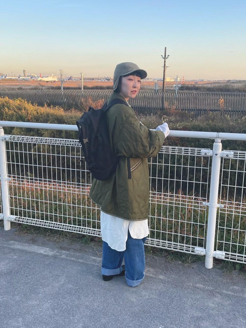 ブラック系のローファー、グリーン系のキャップを着用したレディースの冬コーディネートの2枚目の写真