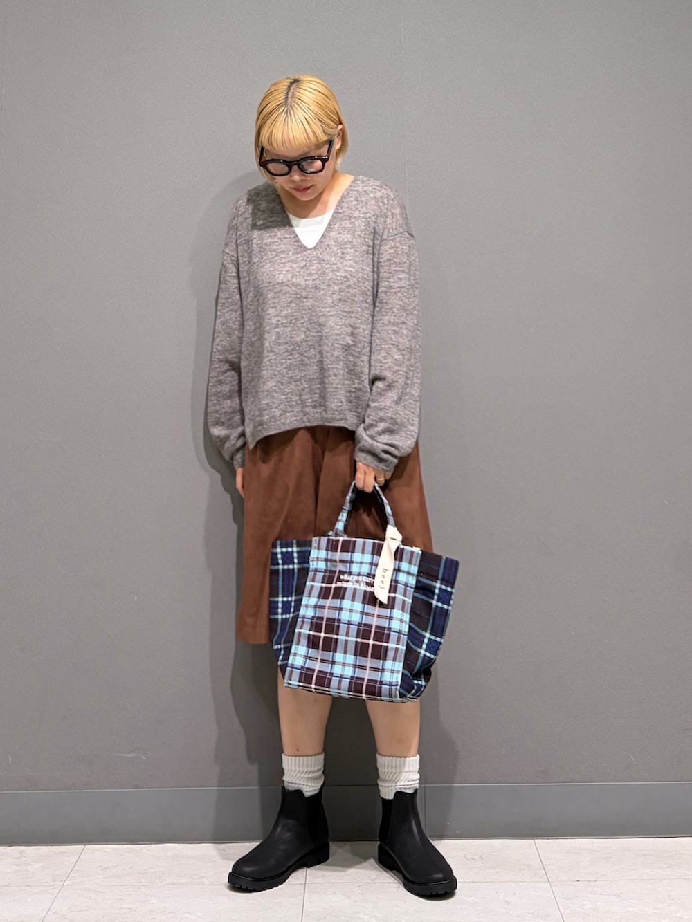 グレー系のニット/セーター、ブラウン系のその他パンツ、ブラック系のレインシューズを着用したレディースの秋コーディネートの8枚目の写真