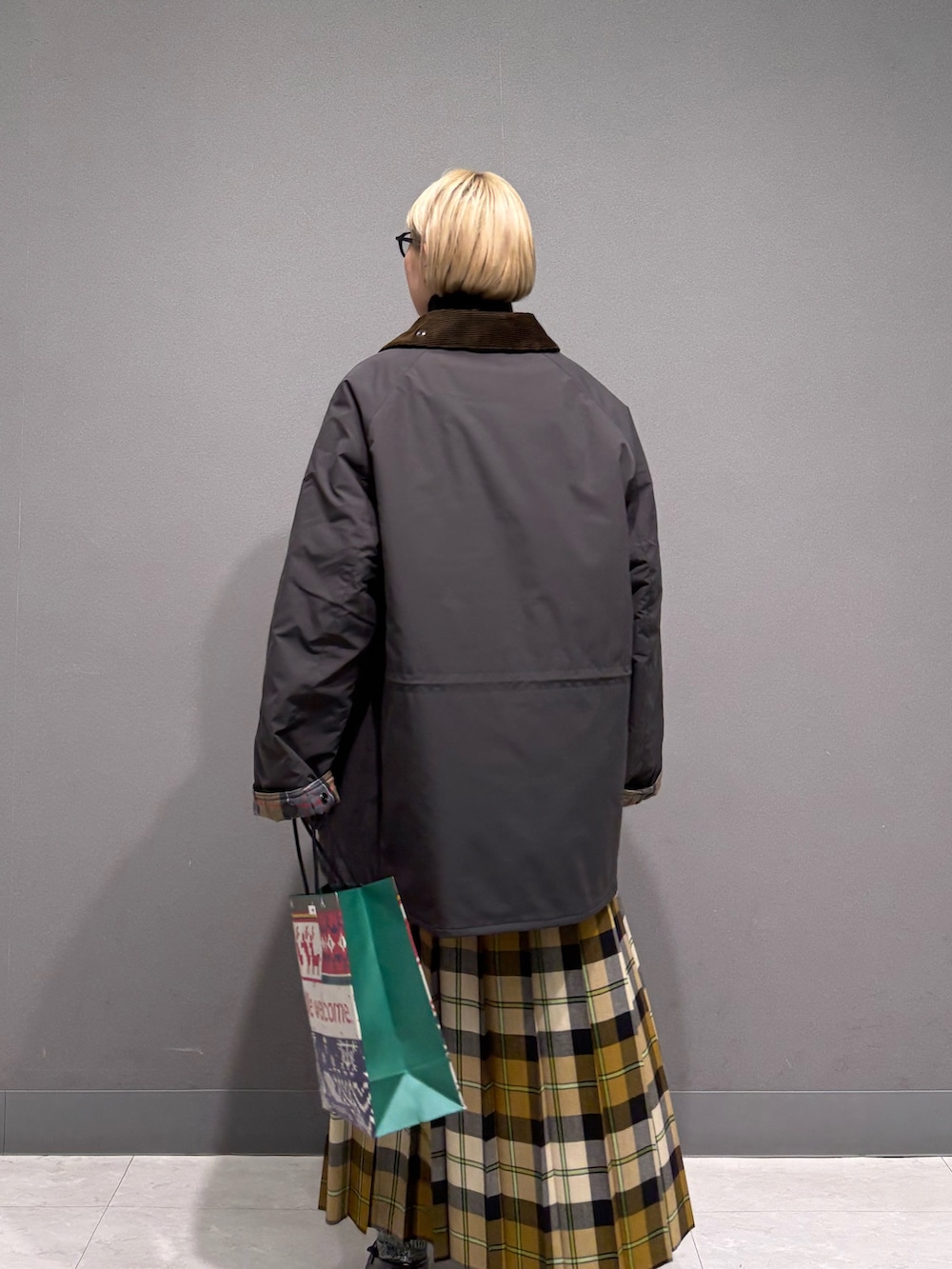 ブラウン系のニット/セーター、ベージュ系のスカート、グレー系のその他アウターを着用したレディースの冬コーディネートの3枚目の写真