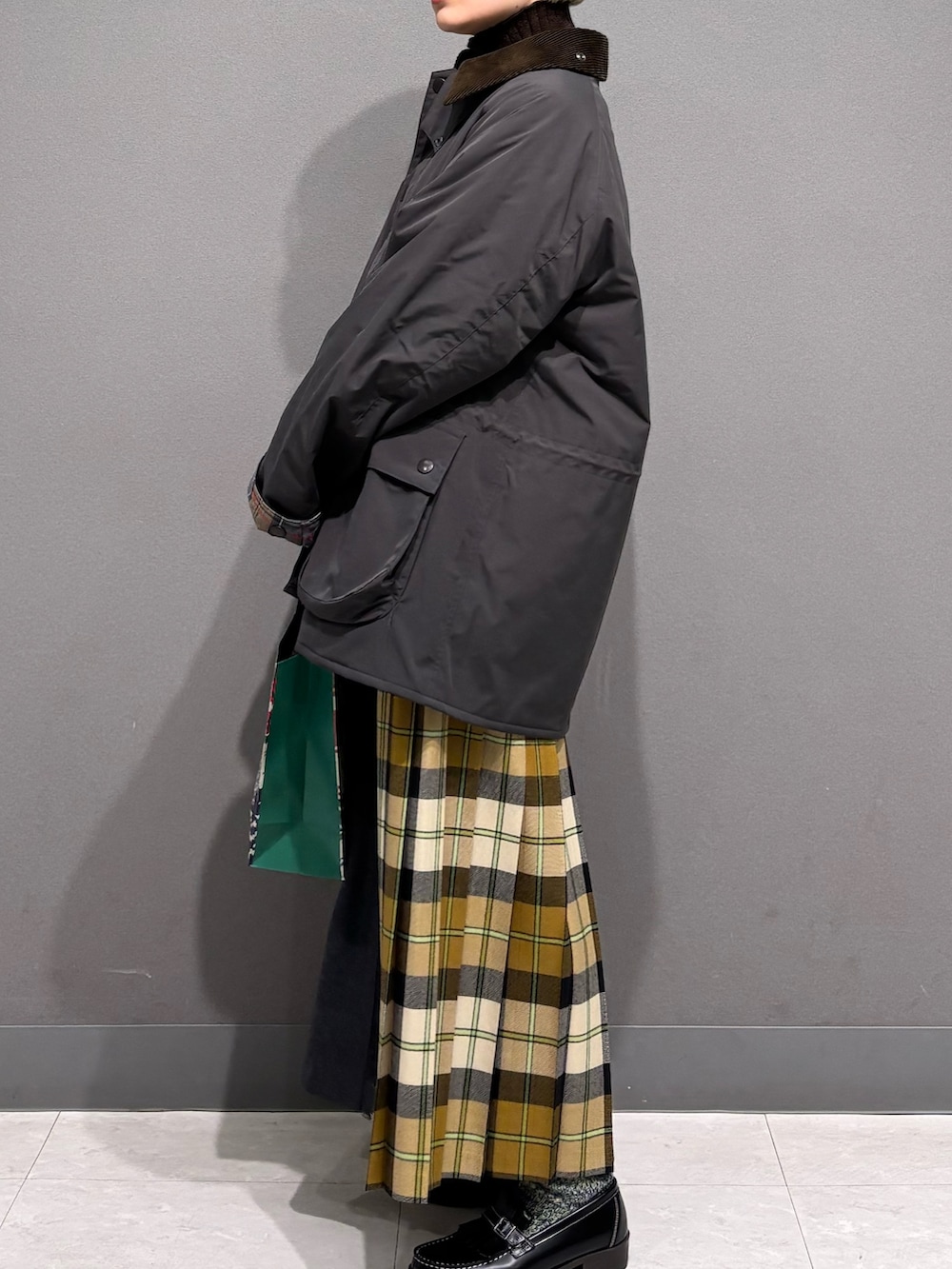 ブラウン系のニット/セーター、ベージュ系のスカート、グレー系のその他アウターを着用したレディースの冬コーディネートの4枚目の写真