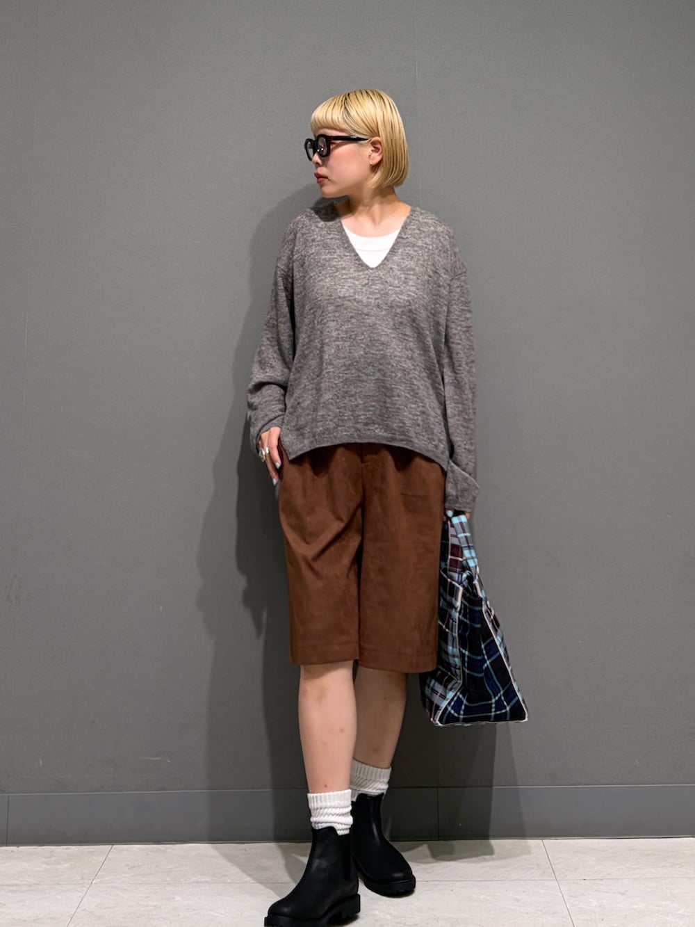 グレー系のニット/セーター、ブラウン系のその他パンツ、ブラック系のレインシューズを着用したレディースの秋コーディネートの6枚目の写真